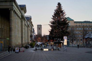 Stuttgart, Germany - December 31, 2021: Christmas tree in the city. Fir tree on historical square. Subway station and main station.