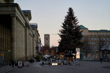 Stuttgart, Germany - December 31, 2021: Christmas tree in the city. Fir tree on historical square. Subway station and main station.