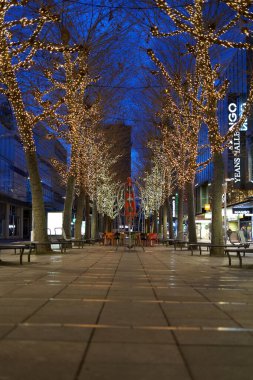 Stuttgart, Germany - January 6, 2022: Avenue with decorated Christmas trees in the streets of the city in the early morning. Deep perspective.