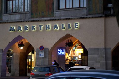 Stuttgart, Almanya - 31 Aralık 2021: Şehirde Noel zamanı pazar salonunun (Markthalle) kapanışı. Aydınlatılmış harflerle bina cephesi. Şenlikli mimari kemerler..