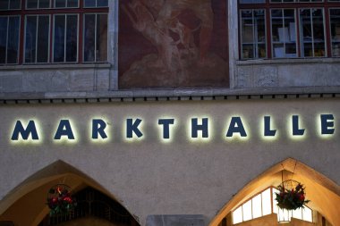 Stuttgart, Almanya - 31 Aralık 2021: Şehirde Noel zamanı pazar salonunun (Markthalle) kapanışı. Aydınlatılmış harflerle bina cephesi. Şenlikli mimari kemerler..