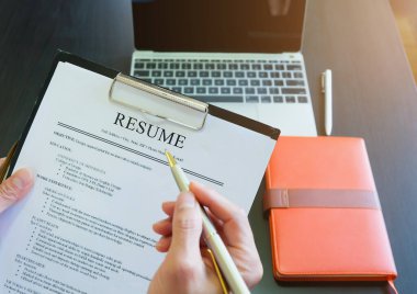 Yakın plan iş adamları iş için adam toplamak için özgeçmişlerini okuyor.