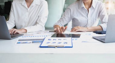 Pazarlama, Finansal, Muhasebe, Planlama, Kadın işadamları ve ekonomistlerden oluşan bir ekip, şirkete fayda sağlamak için hesap makinesi ve bilgisayar ve grafik belgeleri kullanıyor..