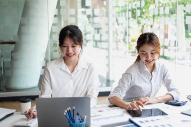Pazarlama, Finansal, Muhasebe, Planlama, Kadın işadamları ve ekonomistlerden oluşan bir ekip, şirkete fayda sağlamak için hesap makinesi ve bilgisayar ve grafik belgeleri kullanıyor..
