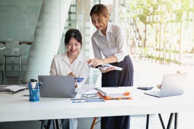 Pazarlama, Finansal, Muhasebe, Planlama, Kadın işadamları ve ekonomistlerden oluşan bir ekip, şirkete fayda sağlamak için hesap makinesi ve bilgisayar ve grafik belgeleri kullanıyor..