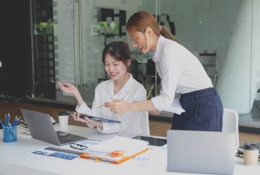 Pazarlama, Finansal, Muhasebe, Planlama, Kadın işadamları ve ekonomistlerden oluşan bir ekip, şirkete fayda sağlamak için hesap makinesi ve bilgisayar ve grafik belgeleri kullanıyor..