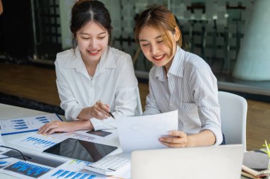 Pazarlama, Finansal, Muhasebe, Planlama, Kadın işadamları ve ekonomistlerden oluşan bir ekip, şirkete fayda sağlamak için hesap makinesi ve bilgisayar ve grafik belgeleri kullanıyor..