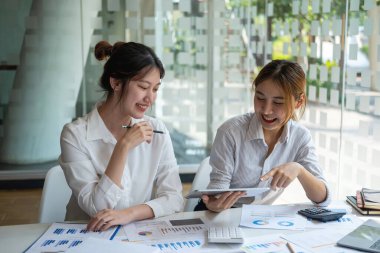 Pazarlama, Finansal, Muhasebe, Planlama, Kadın işadamları ve ekonomistlerden oluşan bir ekip, şirkete fayda sağlamak için hesap makinesi ve bilgisayar ve grafik belgeleri kullanıyor..