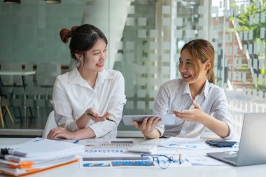 Pazarlama, Finansal, Muhasebe, Planlama, Kadın işadamları ve ekonomistlerden oluşan bir ekip, şirkete fayda sağlamak için hesap makinesi ve bilgisayar ve grafik belgeleri kullanıyor..