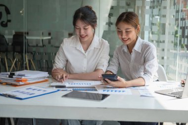 Pazarlama, Finansal, Muhasebe, Planlama, İş Kadınları Ekibi şirket sonuçlarını ve karlarını grafik istatistikleriyle analiz eder. Şirketin bakiyesini hesaplamak için dizüstü bilgisayar ve hesap makinesi kullanın.