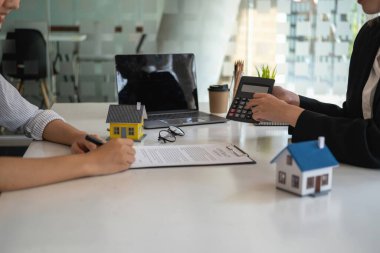 Ev ve arazi satın alma, teminat, sözleşme ve anlaşma bir emlak şirketinin çalışanı arazi ve binaların satışı sözleşmesi tamamlandıktan sonra evi ve anahtarları teslim eder..