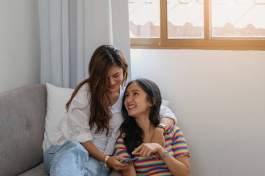 Igbtq lgbt konsepti homoseksüel iki güzel kadın birbirlerini seviyorlar ve evlerinde mutlu mesut akıllı telefonlar çalıyorlar.