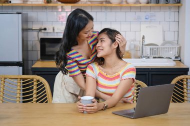 lgbtq lgbt konsepti homoseksüellik iki güzel kadın birbirlerine sevgilerini ifade ederek rahat evlerinde dizüstü bilgisayar oynuyorlar..
