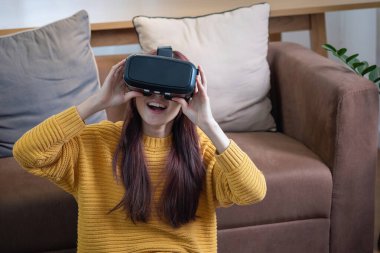 Tatilde stresten kurtuldum. Mutlu Asyalı kadın evde dinleniyor. Tatilde VR 3 boyutlu sanal gerçeklik oyunu oynuyor..