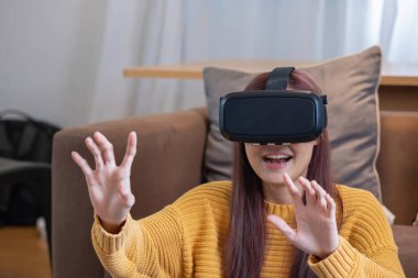 Tatilde stresten kurtuldum. Mutlu Asyalı kadın evde dinleniyor. Tatilde VR 3 boyutlu sanal gerçeklik oyunu oynuyor..