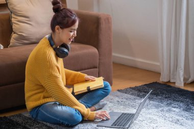 Rahatla, stresten kurtul, tatil, mutlu, Asyalı kadın evde rahatla dizüstü bilgisayarını film izlemek ve tatilde müzik dinlemek için kullan..