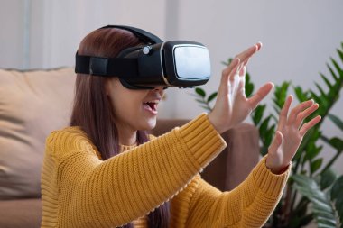 Tatilde stresten kurtuldum. Mutlu Asyalı kadın evde dinleniyor. Tatilde VR 3 boyutlu sanal gerçeklik oyunu oynuyor..