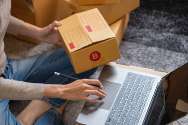 Genç Asyalı KOBİ işadamı küçük ve kutulanmış bir KOBİ işine çevrimiçi olarak başlıyor. Çevrimiçi KOBİ iş kavramı.