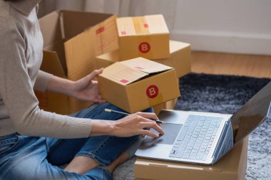 Genç Asyalı KOBİ işadamı küçük ve kutulanmış bir KOBİ işine çevrimiçi olarak başlıyor. Çevrimiçi KOBİ iş kavramı.