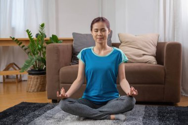 İşten sonra evde yoga yapan bir kadın. Stres atma, kas gevşemesi, nefes egzersizleri, egzersiz, meditasyon..