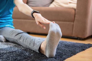 Stres atmak, kasları gevşetmek, nefes almak, egzersiz yapmak, meditasyon yapmak. Tatilde evde yoga ve kas yapan bir kadın..