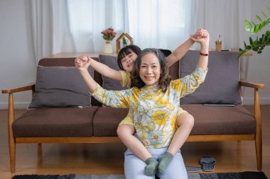 Bir büyükanne ve torunun portresi, aile içinde sıcaklık ve sevgi yaratmak için ev aktiviteleri yapıyor ve birbirlerine sevgi gösteriyorlar..