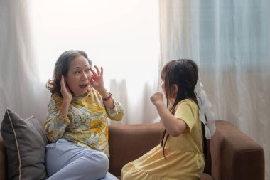 Evin içinde kanepede otururken büyükanneme bağıran bir torunun portresi..