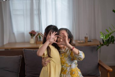 Bir büyükanne ve torunun portresi, aile içinde sıcaklık ve sevgi yaratmak için ev aktiviteleri yapıyor ve birbirlerine sevgi gösteriyorlar..