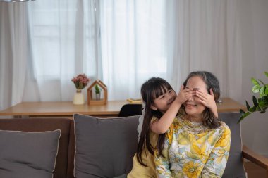 Bir büyükanne ve torunun portresi, aile içinde sıcaklık ve sevgi yaratmak için ev aktiviteleri yapıyor ve birbirlerine sevgi gösteriyorlar..
