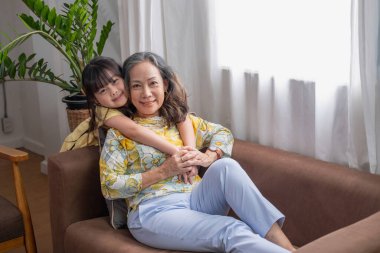 Bir büyükanne ve torunun portresi, aile içinde sıcaklık ve sevgi yaratmak için ev aktiviteleri yapıyor ve birbirlerine sevgi gösteriyorlar..