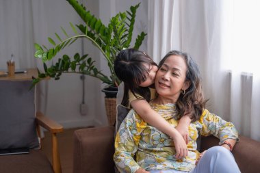 Bir büyükanne ve torunun portresi, aile içinde sıcaklık ve sevgi yaratmak için ev aktiviteleri yapıyor ve birbirlerine sevgi gösteriyorlar..