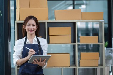 Young businesswoman using a tablet to check online product sales