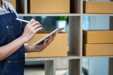 Young businesswoman using a tablet to check online product sales