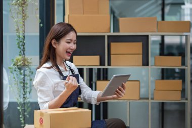 Young businesswoman using a tablet to check online product sales