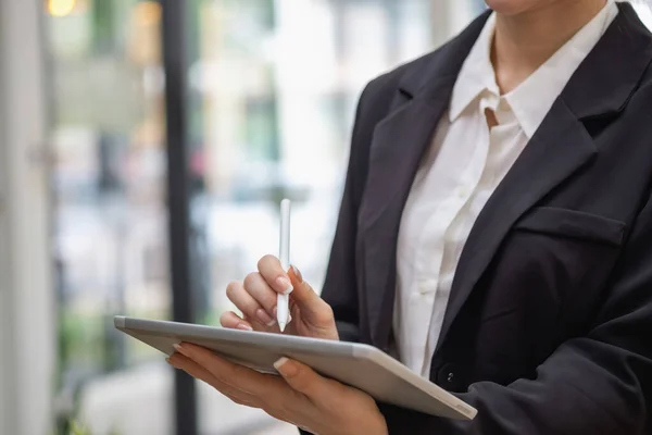 marketing, finance, accounting, planning, businesswoman holding a tablet Analyze company results and profits with graph statistics. Use a laptop computer and a calculator to calculate your company balance.