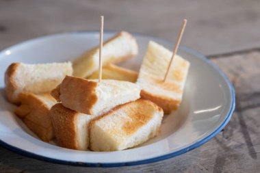 Kahvaltıda kremayla birlikte dilimlenmiş ekmek ve taze süt..