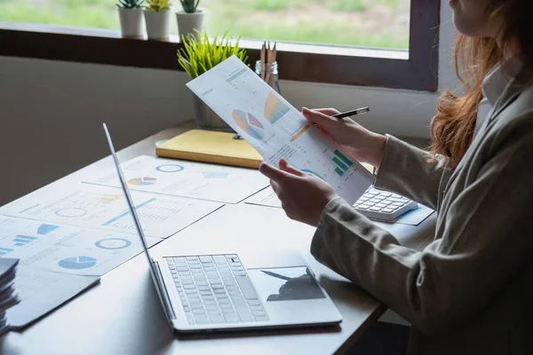 Businesswoman presenting profit data with graphs to her supervisor via laptop computer.