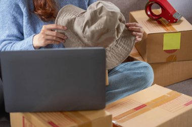 Genç Asyalı KOBİ işadamı küçük ve kutulanmış bir KOBİ işine çevrimiçi olarak başlıyor. Çevrimiçi KOBİ iş kavramı.