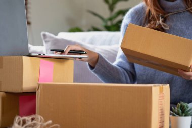 Genç Asyalı KOBİ işadamı küçük ve kutulanmış bir KOBİ işine çevrimiçi olarak başlıyor. Çevrimiçi KOBİ iş kavramı.