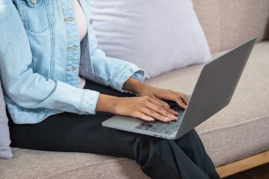 Afrikalı bir kadın, Amerikalı, bilgisayar kullanıyor ve çevrimiçi öğrenim için kulaklık takıyor..