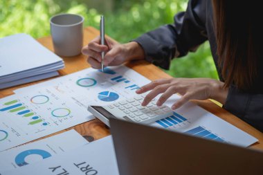 Pazarlama, Finansal, Muhasebe, Planlama, İş kadınları şirket sonuçlarını ve karlarını grafik istatistikleriyle analiz eder. Şirketi hesaplamak için dizüstü bilgisayar ve hesap makinesi kullanın..