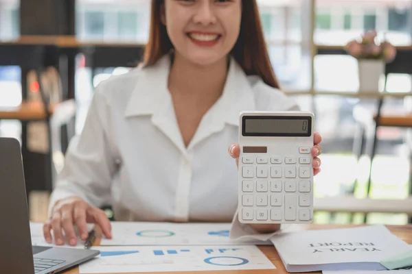 marketing, finance, accounting, planning, female accountant using laptop calculator and documents, charts, graphs in the analysis of the company's profit