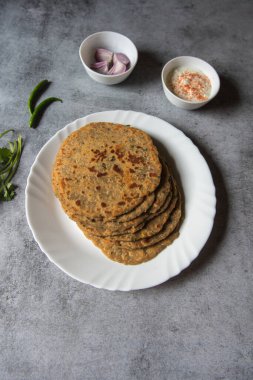 Popüler kahvaltı öğesi aloo ka paratha ya da beyaz tabakta doldurulmuş patates. Üst görünüm.