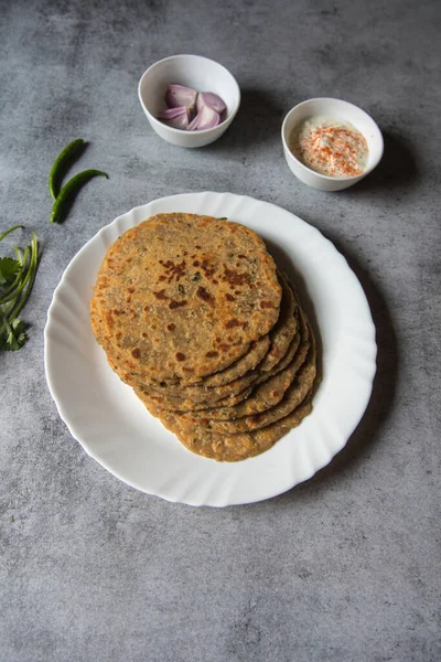 Popüler kahvaltı öğesi aloo ka paratha ya da beyaz tabakta doldurulmuş patates. Üst görünüm.
