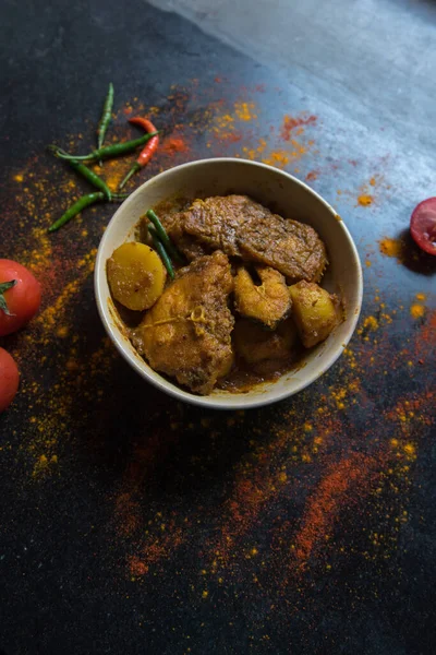 Popular Bengali dish fish kalia or masala curry served in a bowl on a dark background. Top view.