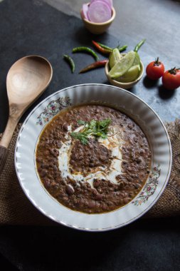 Daal makhni ya da siyah mercimek çorbası sosla birlikte bir kasede servis edilir. Seçici odak.