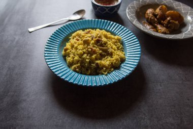 Pulao veya basmati pilavı Hint baharatları ve mavi bir kasede servis edilen kuru meyvelerle yapılır. Yaklaş, seçici odaklanma.