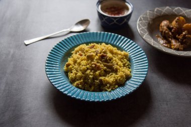 Pulao veya basmati pilavı Hint baharatları ve mavi bir kasede servis edilen kuru meyvelerle yapılır. Yaklaş, seçici odaklanma.