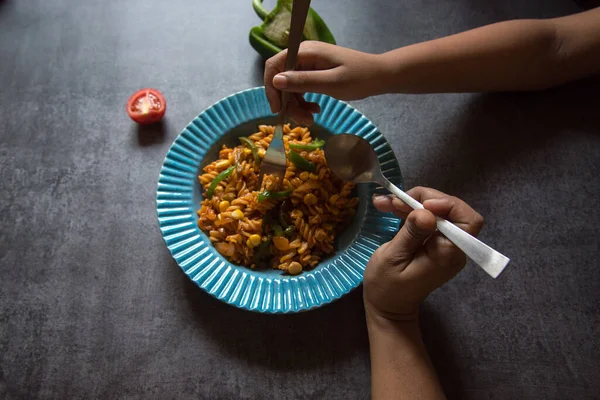 Hand of a woman and child sharing food from the same plate. Close up, selective focus. Concept of sharing is caring.