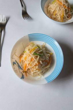 Arka planda bir kasede servis edilen kızarmış şehriye. Üst görünüm, seçici odak.